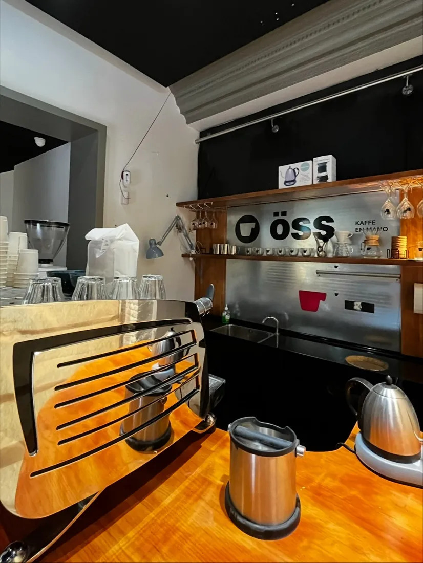 Barra con la máquina de espresso y el cartel öss